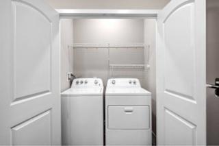 A white laundry room with a washer and dryer at Aventura at Wentzville I & II Apartments, Wentzville, 63385