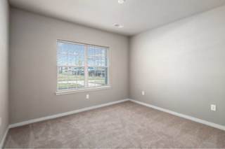 A room with a carpeted floor and a window at Aventura at Wentzville I & II Apartments, Wentzville, Missouri