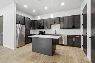 A modern kitchen with a large island and stainless steel appliances.