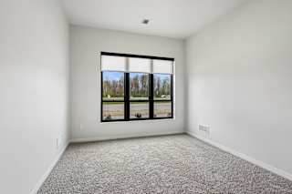 A room with a large window and carpeted floor.