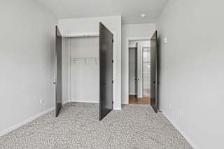 A room with a carpeted floor and a white wall.
