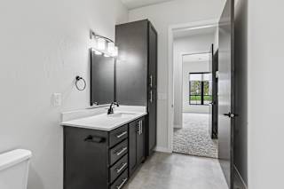 A bathroom with a sink, mirror, and cabinets.