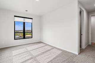 A room with a large window and carpeted floor.