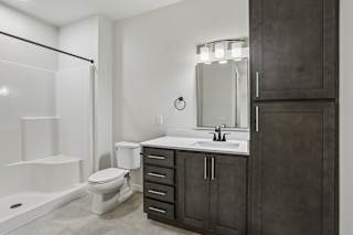 A bathroom with a toilet, sink, and mirror.
