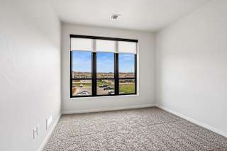 A room with a large window overlooking a parking lot.