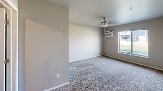 an empty living room with a large window and white walls
