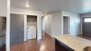 a kitchen with a washer and dryer and a door into a laundry room