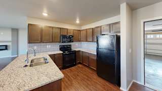 a kitchen with a black refrigerator and a sink