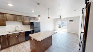 A kitchen with wooden cabinets and a black refrigerator.