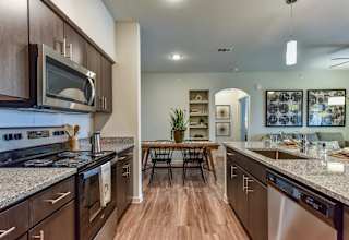 Galley kitchen with stainless steel appliances and dining area at High Point Preserve Apartments, Austin