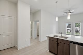 Kitchen with stainless steel sink and pendant lights at Cantarra Apartments, Manor, TX 78653