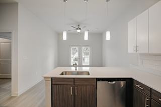 Kitchen island with sink and pendant lighting at Cantarra Apartments, Manor, TX