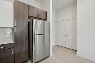 Kitchen with stainless refrigerator and pantry storage at Cantarra Apartments, Manor, 78653