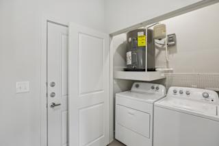 Laundry closet with side by side washer and dryer at Cantarra Apartments, Manor, Texas