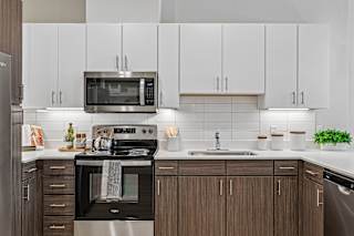A modern kitchen with a stainless steel oven and microwave.