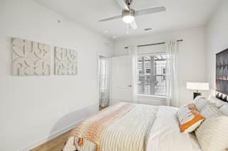 Bright bedroom with ceiling fan and window blinds at Matador Apartments, Austin