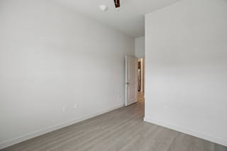 Empty bedroom with open door to hallway at Cantarra Apartments, Manor, 78653