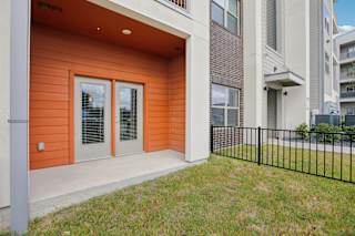 Private patio with french doors and metal railing at Cantarra Apartments, Texas