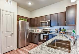 Kitchen with stainless steel appliances and granite countertops 1 at High Point Preserve Apartments, Austin, TX 78724