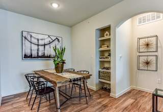 Dining area with wood table and builtin shelving at High Point Preserve Apartments, Austin, TX