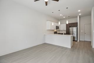 Open living and dining area with kitchen peninsula at Cantarra Apartments, Texas, 78653