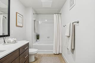 A white bathroom with a toilet, sink, and bathtub. at ThreeTwenty at the Vybe Apartments, Texas, 78640