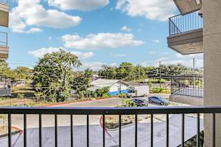 Balcony view overlooking parking area and trees at Matador Apartments, Texas, 78745