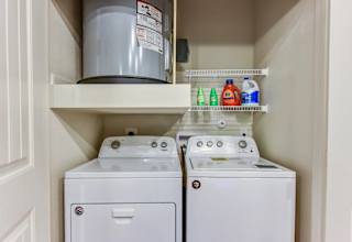Laundry closet with top load washer and dryer at High Point Preserve Apartments, Austin, Texas