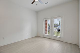 Empty room with french doors and light flooring at Cantarra Apartments, Manor, 78653