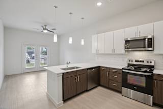 Kitchen with white countertops and stainless appliances at Cantarra Apartments, Manor, Texas