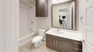 A bathroom with a toilet, sink, and mirror. at Bridge at Speyside Apartments, Austin, TX, 78754