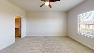 A room with a ceiling fan and carpeted floor. at Bridge at Speyside Apartments, Texas