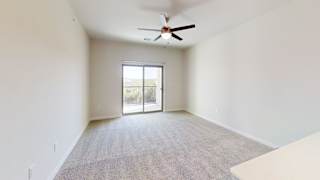 A room with a ceiling fan and a sliding glass door. at Bridge at Speyside Apartments, Texas, 78754