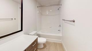 A white bathroom with a toilet, sink, and bathtub. at ThreeTwenty at the Vybe Apartments, Texas, 78640