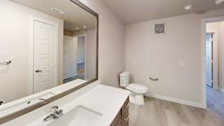 A bathroom with a toilet, sink, and mirror. at Bridge at Speyside Apartments, Texas, 78754