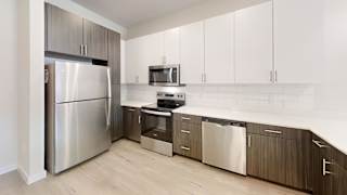 a kitchen with white cabinets and stainless steel appliances at Bridge at Speyside Apartments, Austin, Texas