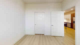 A room with two white doors and a wooden floor.