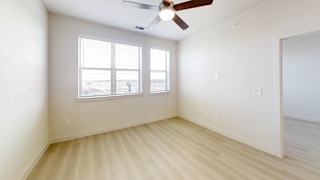 A room with a ceiling fan and a window.
