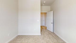 a bedroom with an open door and a hallway to a closet at Bridge at Speyside Apartments, Austin, TX, 78754
