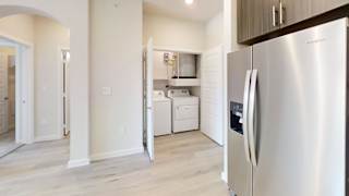 a renovated kitchen with stainless steel appliances and white cabinets at Bridge at Speyside Apartments, Austin, Texas