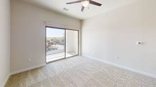 an empty living room with a sliding glass door to a balcony at Bridge at Speyside Apartments, Texas, 78754