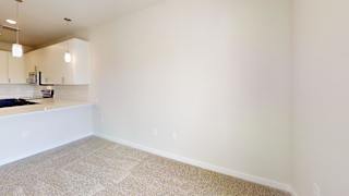 a living room and kitchen with white walls and tile floor at Bridge at Speyside Apartments, Austin, 78754