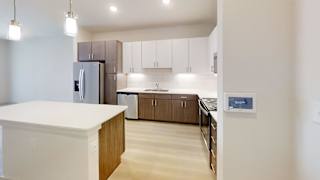 A kitchen with a white counter top and wooden cabinets.