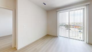 A room with a sliding glass door leading to a balcony.