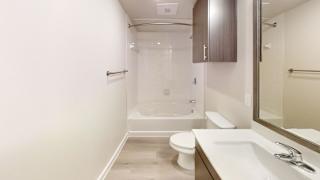 A white bathroom with a toilet, sink, and bathtub. at Bridge at Speyside Apartments, Texas