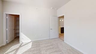 A white room with a carpeted floor and two open doors. at Bridge at Speyside Apartments, Austin