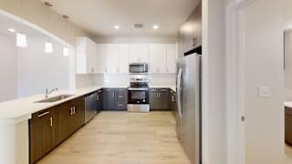 A modern kitchen with a refrigerator, sink, and cabinets. at Bridge at Speyside Apartments, Austin, TX, 78754