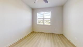A room with a window and a ceiling fan.