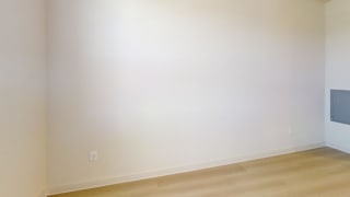 A room with a light colored wall and a wooden floor.