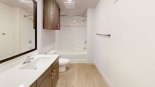 A white sink with a mirror above it. at ThreeTwenty at the Vybe Apartments, Texas
